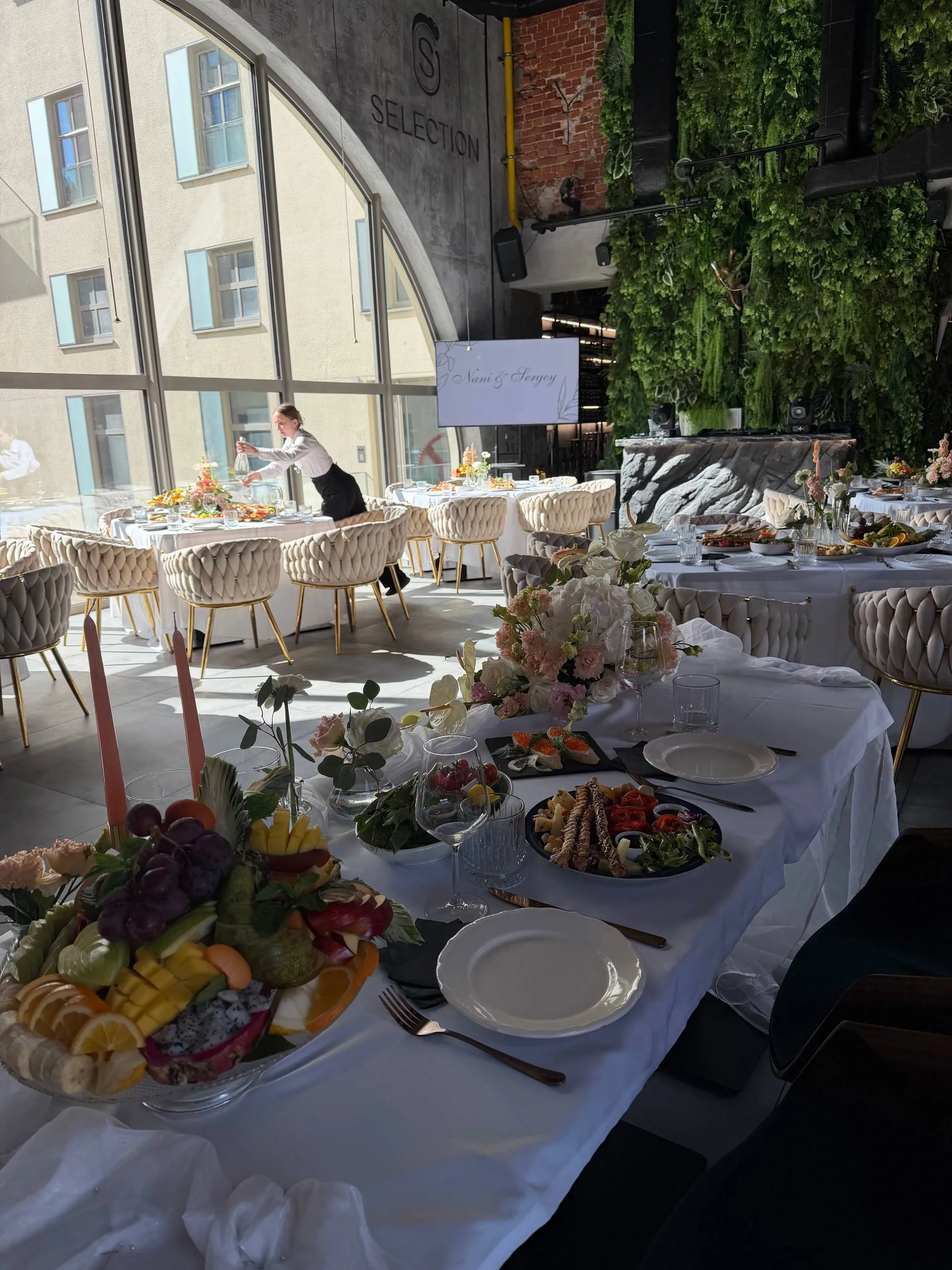 Elegantly set table for a company party at Selection — flowers, fruit and appetizers by a panoramic window